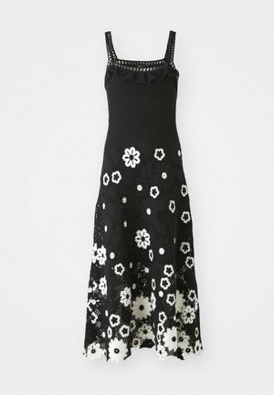 Vestido de ganchillo negro con escote cuadrado, acentos con volantes y patrón floral en blanco. Dobladillo acampanado y textura de encaje intrincada.
