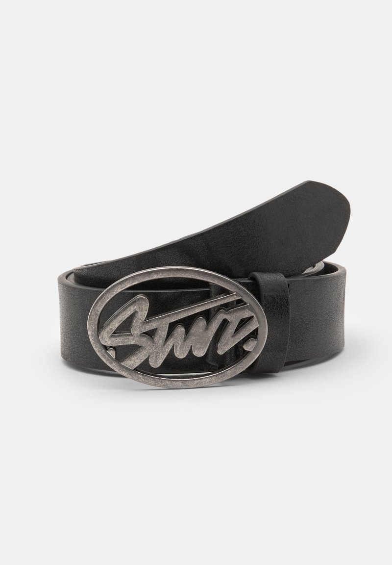 Zwarte lederen riem met een gestructureerde afwerking, voorzien van een rechthoekige zilveren metalen gesp met een gestileerd logo ontwerp.