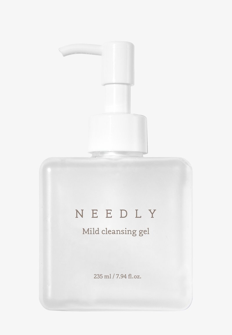Genomskinlig, fyrkantig flaska med vit pumpdispenser. Etiketten lyder "NEEDLY Mild cleansing gel" med en volym på 235 ml / 7,94 fl. oz.