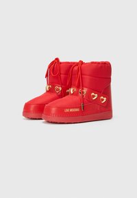 Red padded boots featuring a rounded toe, lace closure, gold heart accents on the side, and "LOVE MOSCHINO" branding on the sole.