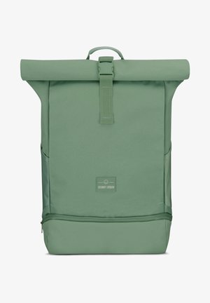 Sac à dos à rabat vert en tissu durable, avec une boucle à l'avant, des poches latérales et un compartiment inférieur zippé pour un espace de rangement supplémentaire.