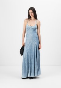 Denim maksi haljina s tankim naramenicama, uskim tijelom i lepršavim suknjom. Svijetloplava boja s suptilnom teksturom i detaljima šivanja.
