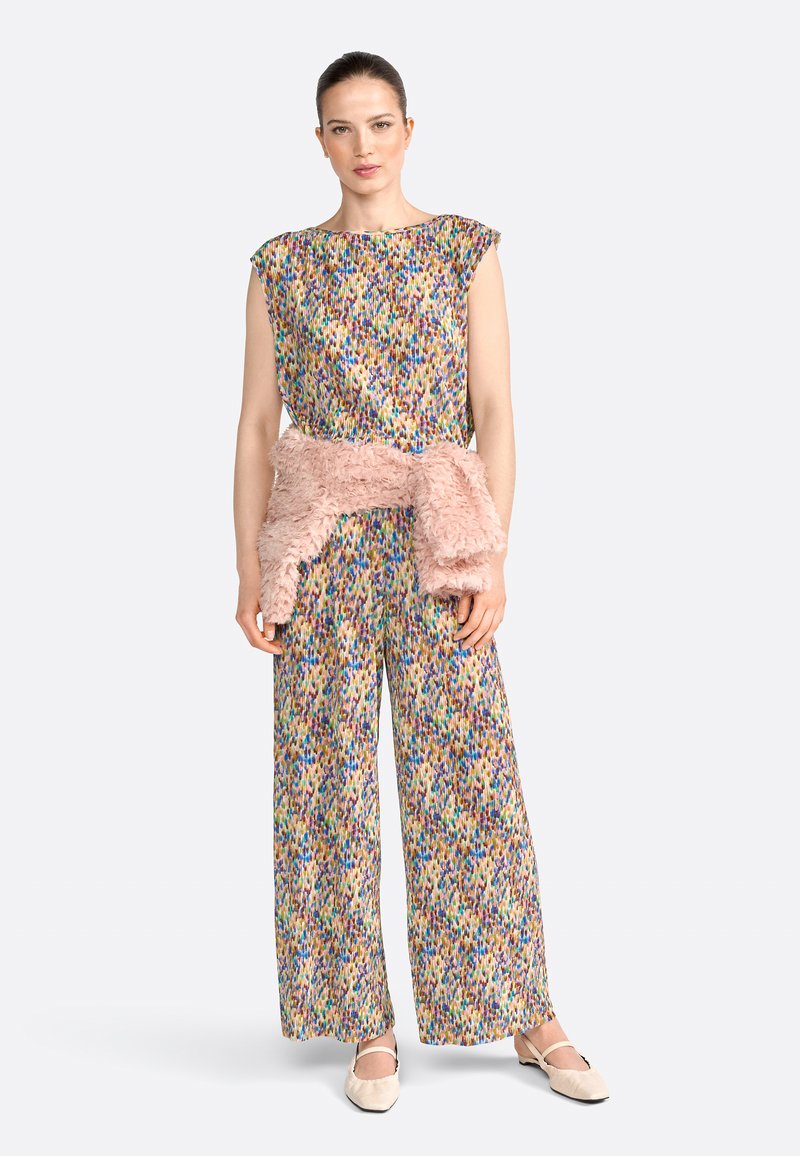 Multicolored, pleated fabric outfit with a loose-fitting top and wide-leg pants; features a soft, pink fur accent around the waist.