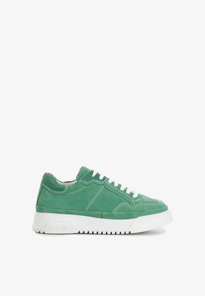 Baskets en daim vert avec lacets blancs, détails de couture et semelle épaisse en caoutchouc blanc affichant le nom de la marque "CAPO NOIR" sur le côté.