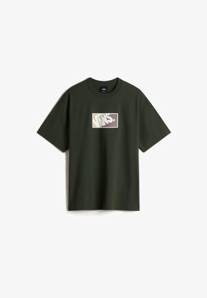 Camiseta de algodón verde de manga corta, con un logo rectangular blanco que lleva "VANS" en amarillo y marrón en el centro.