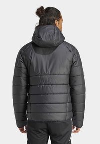 Svart dunjakke med horisontalt quiltet design, justerbar hette og elastiske mansjetter. Glatt tekstur og minimalistisk stil.