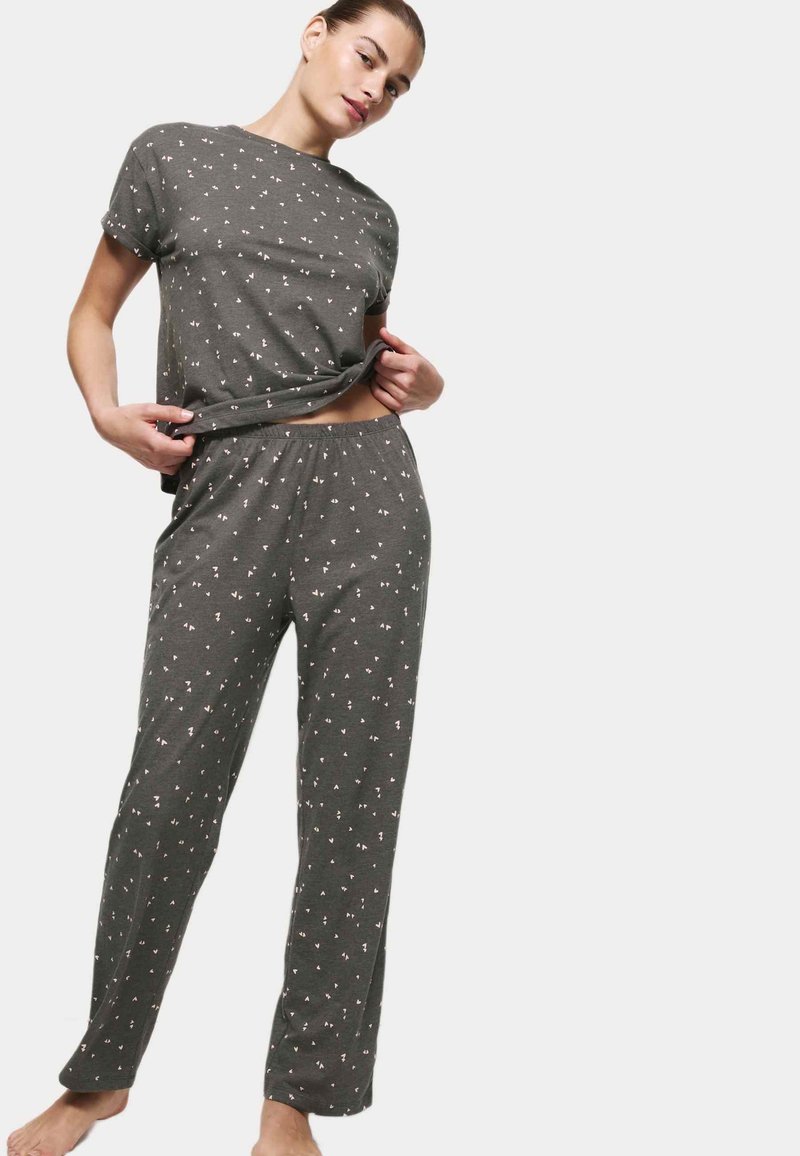 Grau Baumwoll-Pyjama-Set mit kurzärmeligem Oberteil und elastischem Hosenbund, das ein kleines, verstreutes rosa geometrisches Muster aufweist.