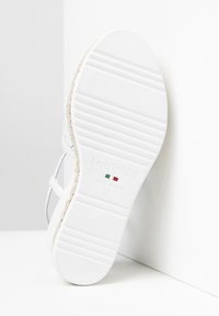 Soletta di sandalo bianca in gomma testurizzata, con un accento in juta intrecciata lungo il bordo. Le marcature includono "NeroGiardini," made in Italy, taglia 37.