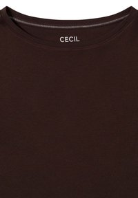 Bruine katoenen T-shirt met een ronde hals. Het label "CECIL" is in het wit op de kraag gedrukt. Soepele textuur zonder patronen.