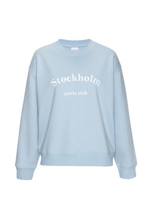 Light blue crewneck sweatshirt with "Stockholm sports club" white text centered on the front, featuring ribbed cuffs and hem.