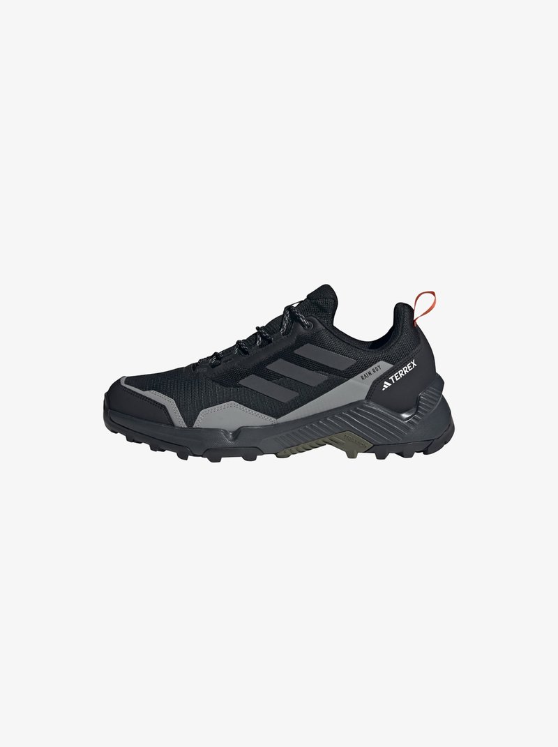 Zwart en grijs sportieve schoen met een bovenwerk van mesh, versterkte neus, rubberen zool met profiel en een contrasterende rode treklip aan de hiel.