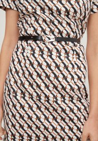 Schwarz-weiß-orange gemustertes Kleid mit figurbetontem Schnitt, ausgestattet mit einem eleganten schwarzen Gürtel und glattem Stoff mit subtiler Sheen.