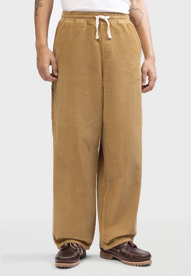 Corduroy pants in a light brown color, featuring an elastic waistband with drawstring, straight fit, and vertical ribbed texture.