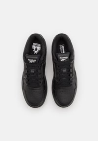 Zwarte sneakers met een bovenwerk van glad leer, geperforeerde neus en vetersluiting. Bevat Reebok-branding op de tong en de binnenzool.