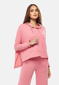 Pink hooded sweatshirt with a front pocket, relaxed fit, and soft texture, paired with matching pants in the same color.