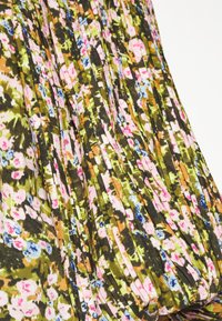 Saia plissada floral em tons de verde, rosa e azul. Feita de um tecido leve com um design texturizado e em camadas.