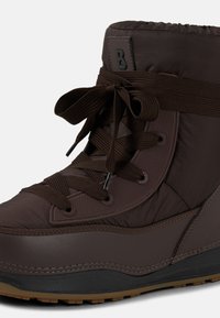 Brązowy ocieplany but z wyściełanym kostką kołnierzem, teksturowaną tkaniną, okrągłymi sznurowadłami oraz gumową podeszwą z wzorzystym bieżnikiem.