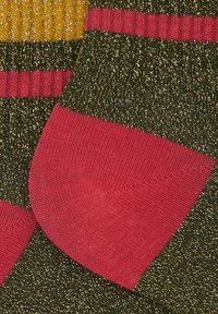 Calzini colorati con una base verde glitterata, accenti rosa e strisce gialle. Texture a costine nella parte superiore e tallone rinforzato.