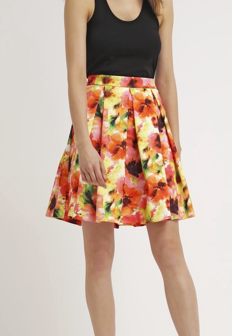 Falda floral en colores vibrantes naranja, rosa y verde. Presenta pliegues y una cintura ajustada. Confeccionada con tela ligera.