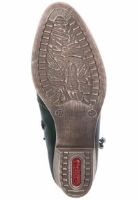 Suela de zapato texturada negra con un dibujo en relieve. Presenta un logotipo rojo prominente y un indicador de tamaño. El lado muestra un material superior verde.