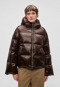 pruun pusa, millel on kõrge krae ja kapuuts, läikiva tekstuuriga, tikitud osadega ja ees lukk