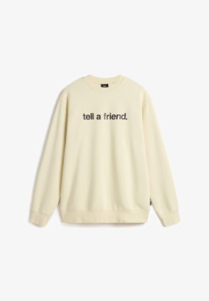 Crèmekleurige sweatshirt met lange mouwen, ronde hals en een tekst aan de voorkant die "vertel het een vriend" zegt. Zachte stof met een relaxte pasvorm.