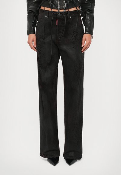 Zwarte wijde pantalon in een zachte, gestructureerde stof met subtiele luipaardprintaccenten. Gestyld met een strakke, korte zwarte leren jas.