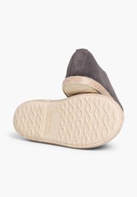 Espadrilla grigia in suede con bordo in corda di paglia e suola in gomma beige testurizzata, caratterizzata da una punta leggermente appuntita e logo impresso sulla suola.