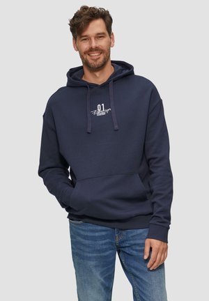 Marineblauwe hoodie van katoenmix met een zak aan de voorkant, koordjes en witte bedrukte tekst. Gestoeld met lichtblauwe jeans.