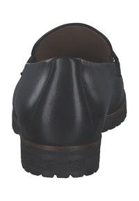Scarpa nera in pelle con retro arrotondato, superficie texturizzata e suola in gomma; presenta un design pulito e senza accessori visibili.