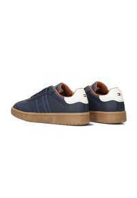 Sneaker blu navy con accenti bianchi sul tallone e interno marrone. Presentano una tomaia testurizzata, punta rotonda e suola in gomma con motivo antiscivolo.