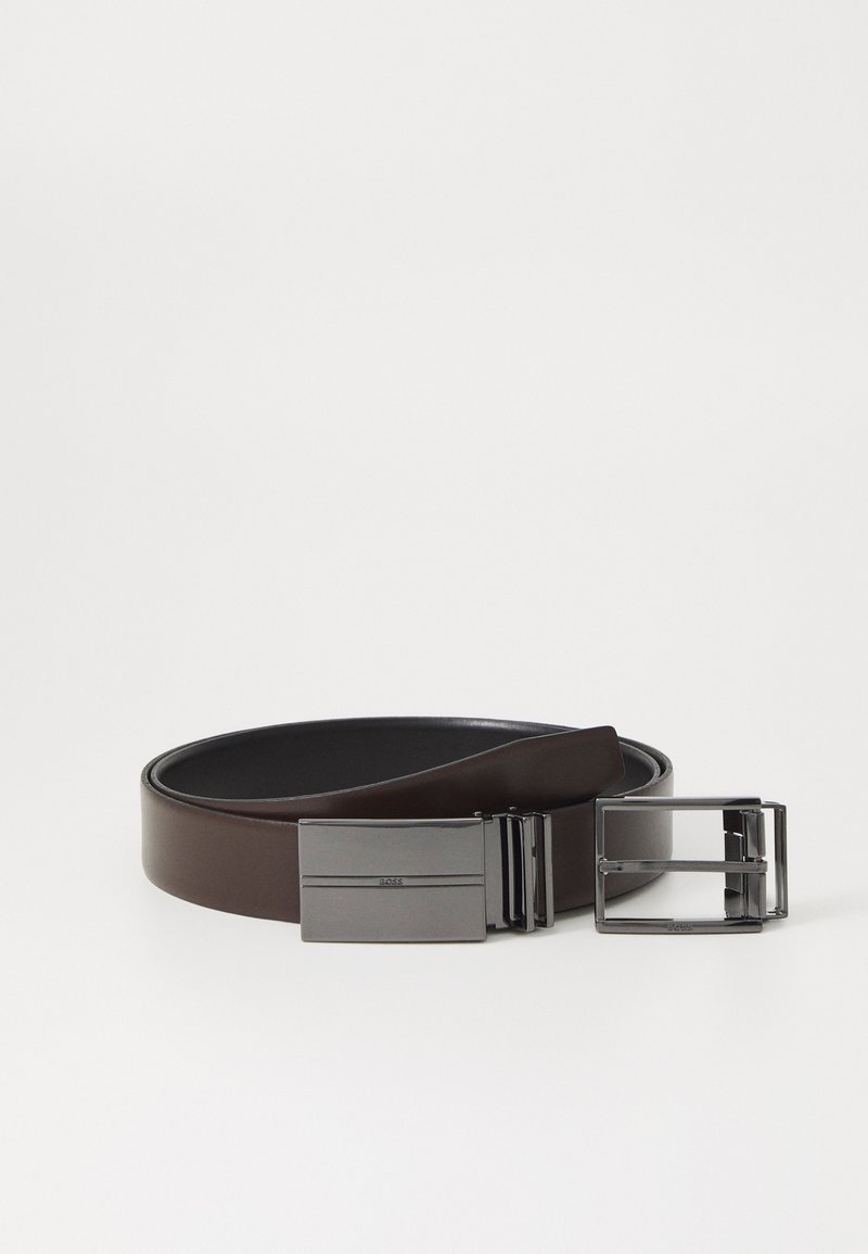 Bruine leren riem met een matte zwarte rechthoekige gesp. Gladde textuur met een minimalistisch ontwerp, voorzien van subtiele merkinformaties op de gesp.