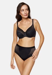 Czarny biustonosz z wzorzystymi siateczkowymi nakładkami, z fiszbinami i regulowanymi ramiączkami, w zestawie z wysokim stanem czarnych majtek z podobnymi detalami.