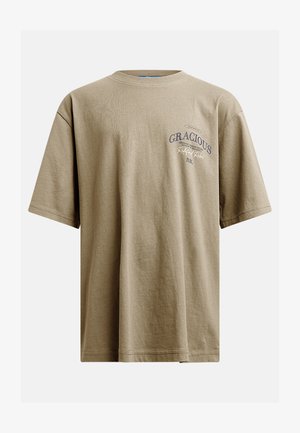 Khaki tričko s krátkym rukávom vyrobené z jemnej bavlny, s okrúhlym výstrihom a prednými textovými grafikami v tmavomodrej farbe. Neformálny, voľný strih.