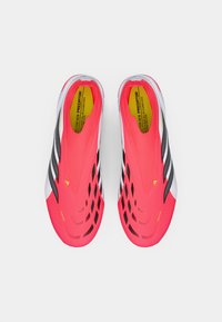 Φωτεινά ροζ υφασμένα ποδοσφαιρικά παπούτσια με μαύρες λεπτομέρειες, αεροδυναμικός σχεδιασμός και ανοικτά πλέγματα; διαμορφωμένα για αυξημένη ευκινησία και πρόσφυση.