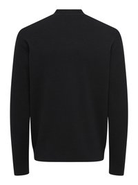 Pull noir en maille, présentant un col rond simple et des manches longues. Texture lisse avec une couleur unie, sans motifs ni accents visibles.