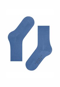 Une paire de chaussettes en coton bleues jusqu'à la cheville, l'une montrant la semelle avec le nom de la marque et la taille imprimés en noir.