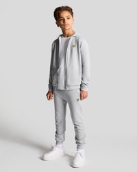 Grå hettegenser med glidelås og gult sommerfugl-logo, kombinert med matchende joggebukser og hvite sneakers. Glatt stoff, avslappet passform, ribbede mansjetter.