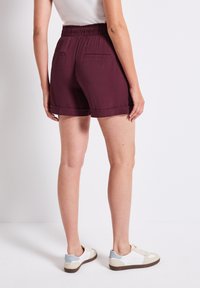 Bordeaux shorts met een relaxte pasvorm, elastische tailleband en omgeslagene randen. Twee achterzakken, gemaakt van een lichtgewicht stof. Te combineren met sneakers.