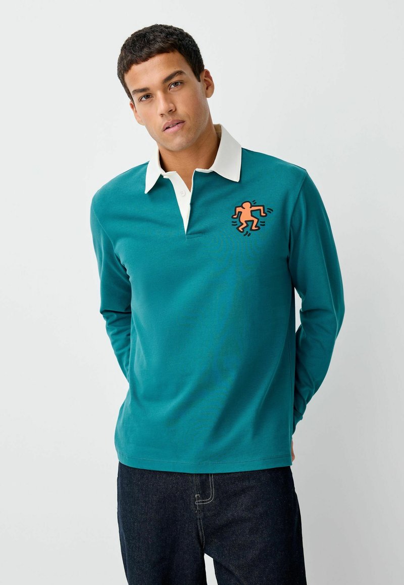 Tyrkysová polokošile s dlouhým rukávem a bílým límečkem, na levé straně s oranžovou grafikou běžící postavy. Materiál: bavlna.