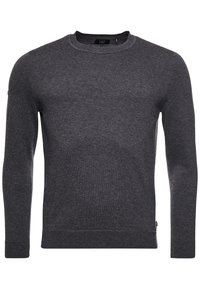 Pull à col rond gris foncé en tissu texturé avec manches longues et poignets côtelés. Présente une petite étiquette logo sur le côté inférieur.