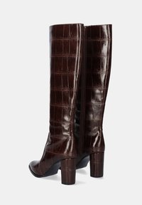 Botas de tacón alto de imitación de cocodrilo en color marrón con un acabado brillante, forma estructurada y detalles de cremallera en la parte trasera. Diseño de punta cuadrada.
