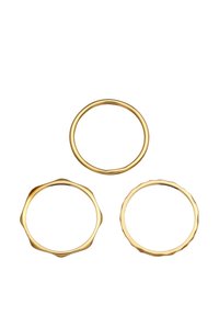 Set di tre anelli d'oro: uno liscio, uno scanalato e uno con un bordo ondulato. Tutti sono sottili e realizzati in metallo con una finitura lucida.
