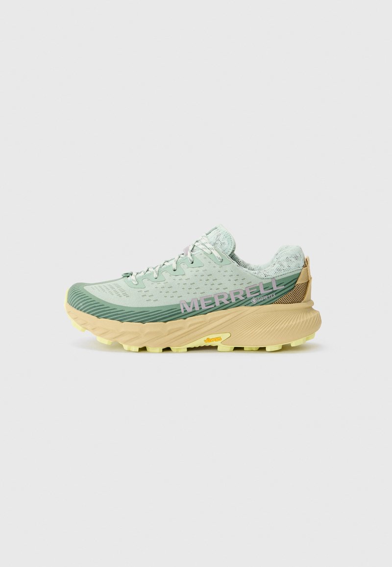 Chaussure de trail running vert clair avec une tige en tissu texturé, semelle jaune contrastante, branding violet et capot de talon renforcé.