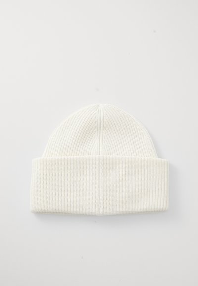White knit beanie with ribbed texture, featuring a folded cuff at the bottom and a rounded top. Designed for warmth and comfort.