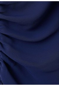 Granatowa tkanina o gładkiej fakturze, z pionowymi marszczeniami, które nadają powierzchni głębię i wymiar.