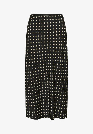 Black midi skirt featuring a smooth fabric, adorned with a repeating pattern of large cream-colored polka dots. Elastic waistband.