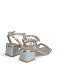 Sandali con tacco in argento, dotati di accenti in strass, design open-toe, cinturini alla caviglia e tacco a blocco con finitura lucida.