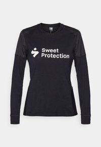 Must tumevarrukasärk, millel on ümmargune kaelus ja võrkkangast detailid õlgadel. Valge "Sweet Protection" logo on selgelt nähtav.