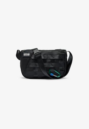 Saco preto de ombro com design trançado, apresentando fecho de correr, alça ajustável e um clip de carabina verde. Tecido texturizado para durabilidade.